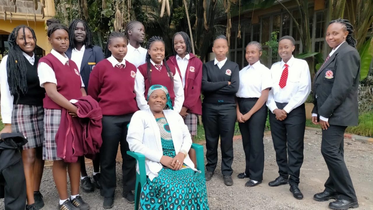 St. Elizabeth Girls students in uniform by the school crest wall